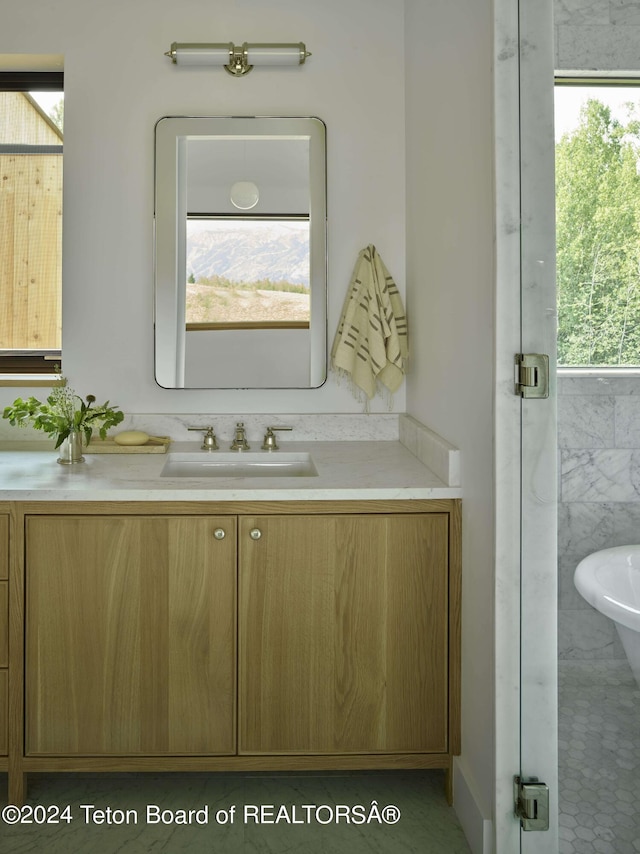 bathroom featuring a washtub, tile patterned floors, and vanity