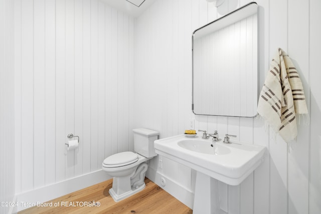 bathroom with hardwood / wood-style floors and toilet