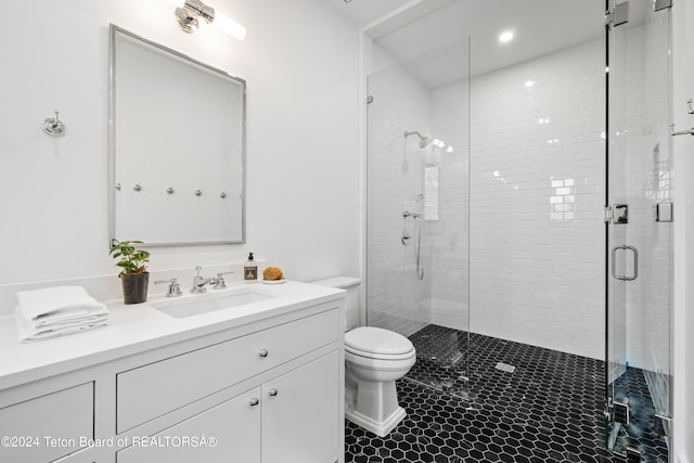 bathroom featuring an enclosed shower, vanity, tile patterned floors, and toilet