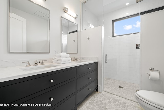 bathroom featuring a shower with shower door, tile patterned floors, toilet, and dual bowl vanity