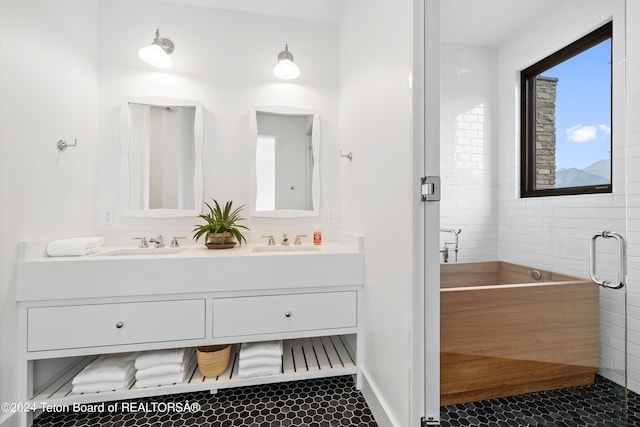 bathroom featuring tile patterned flooring, dual bowl vanity, and tile walls