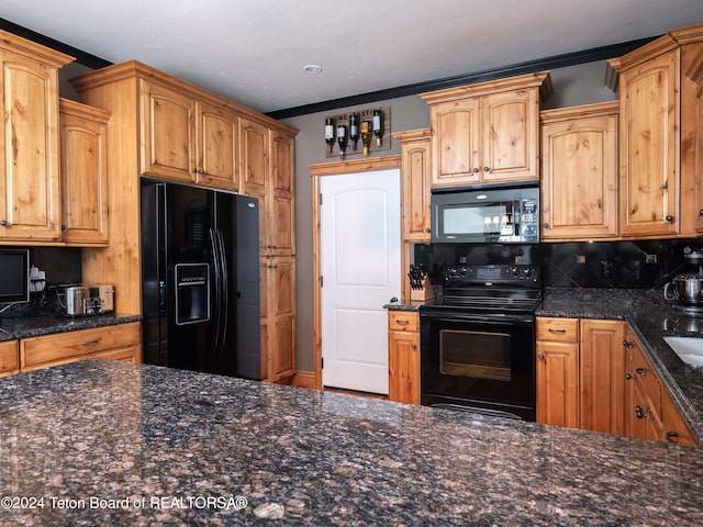 kitchen featuring backsplash, dark stone counters, crown molding, and black appliances