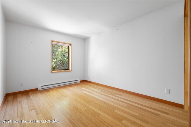 unfurnished room featuring light hardwood / wood-style floors and a baseboard radiator