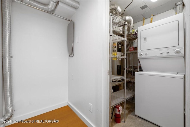 clothes washing area featuring stacked washer / dryer