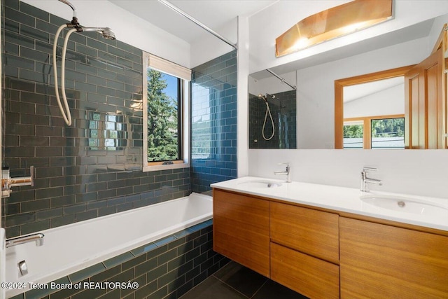 bathroom with tile patterned floors, vanity, and tiled shower / bath