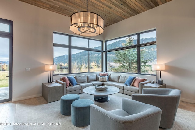 living room with a mountain view, a notable chandelier, and wood ceiling