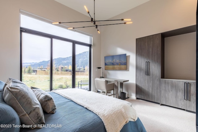 bedroom featuring lofted ceiling, carpet flooring, multiple windows, and a notable chandelier