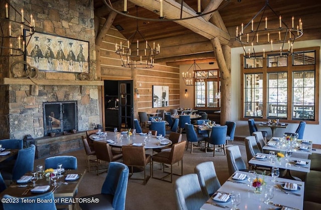 dining area with beamed ceiling, a fireplace, high vaulted ceiling, and wood ceiling