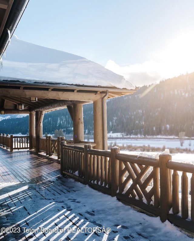 snow covered deck with a mountain view