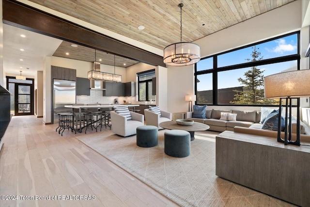 living room featuring a chandelier, light hardwood / wood-style floors, and wood ceiling