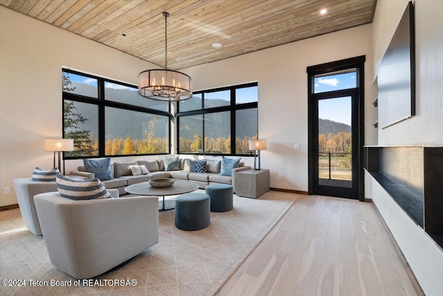 living room with light hardwood / wood-style flooring, an inviting chandelier, wooden ceiling, and a mountain view