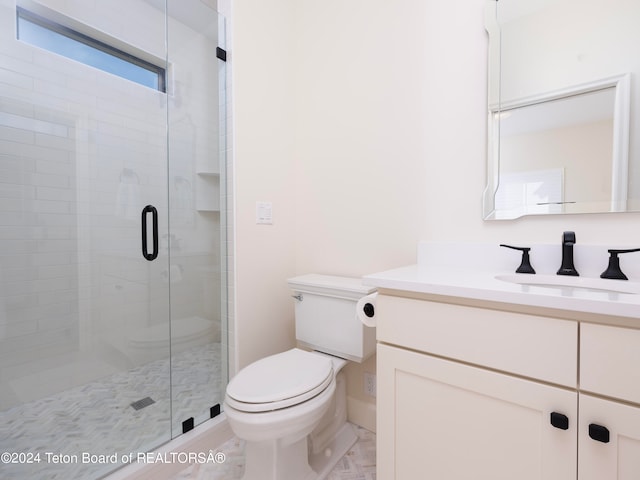 bathroom featuring vanity, toilet, and an enclosed shower