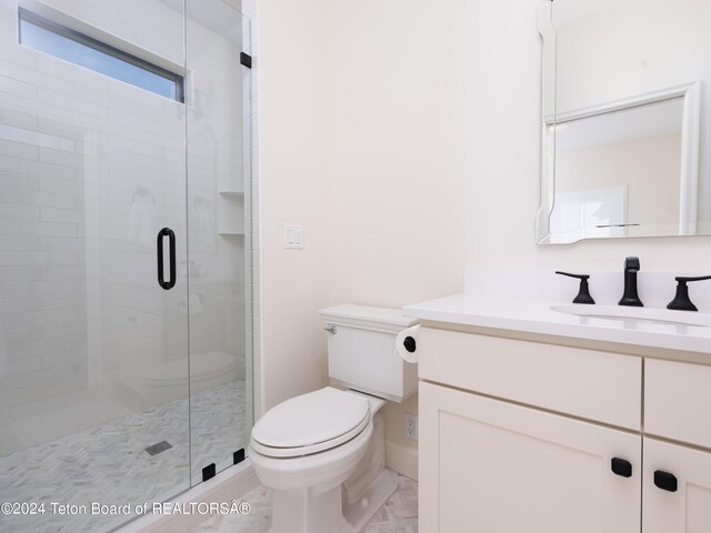 bathroom featuring vanity, toilet, and an enclosed shower