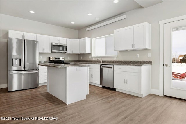 kitchen featuring a kitchen island, white cabinets, and appliances with stainless steel finishes