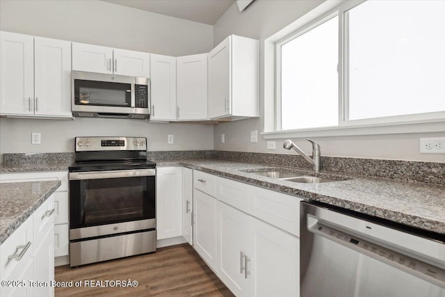 kitchen featuring stainless steel appliances, dark hardwood / wood-style flooring, sink, and white cabinets