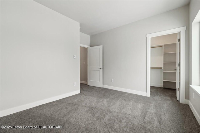 unfurnished bedroom featuring a walk in closet, carpet flooring, and a closet