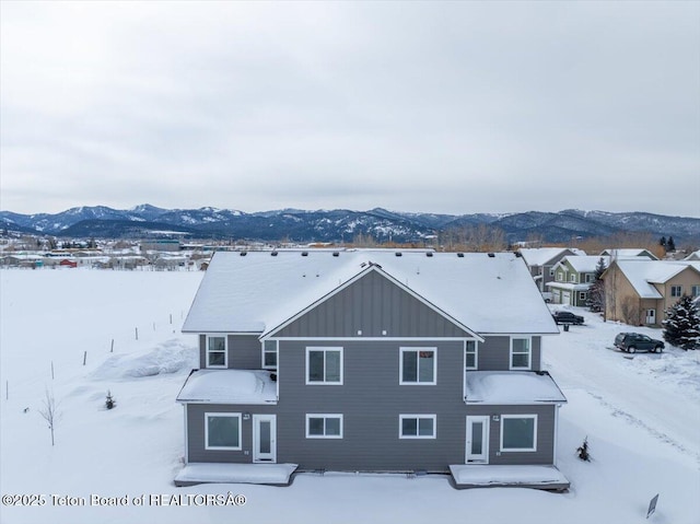 snowy aerial view featuring a mountain view