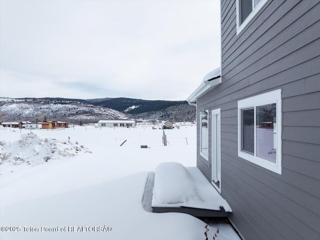 yard covered in snow with a mountain view