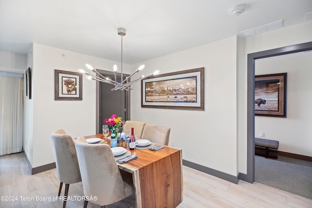 carpeted dining room with a notable chandelier