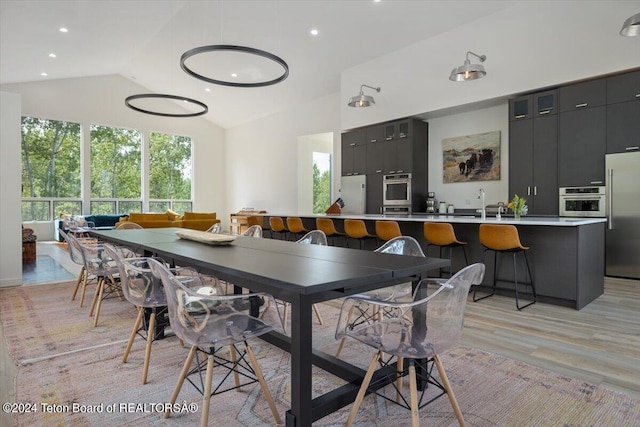 dining room featuring light hardwood / wood-style floors and vaulted ceiling