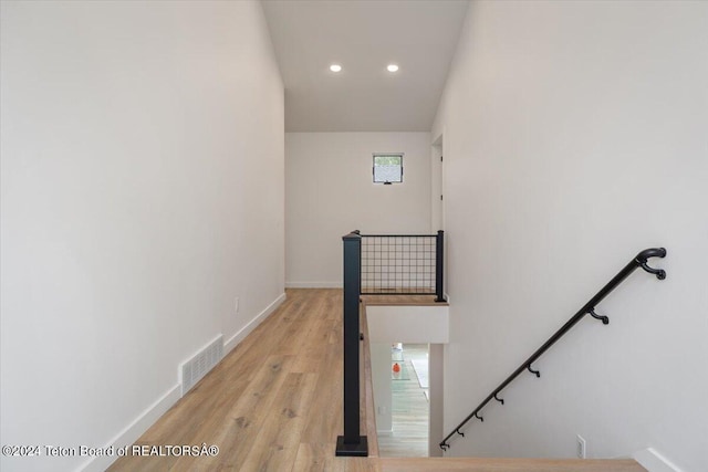 stairway with light hardwood / wood-style flooring and a healthy amount of sunlight