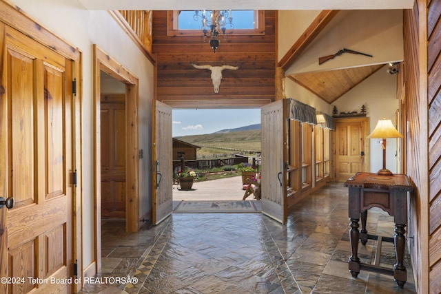 14 Table Top Dr, Dubois, WY 82513 - entrance foyer with high vaulted ceiling, stone tile flooring, wood ceiling, and wooden walls