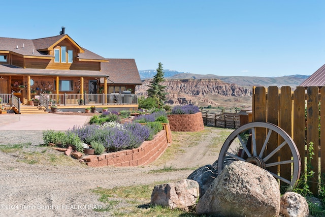 view of yard featuring a mountain view and covered porch