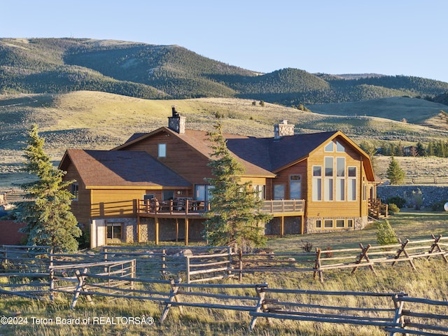 14 Table Top Dr, Dubois, WY 82513 - view of front of home with a chimney, a mountain view, and stone siding