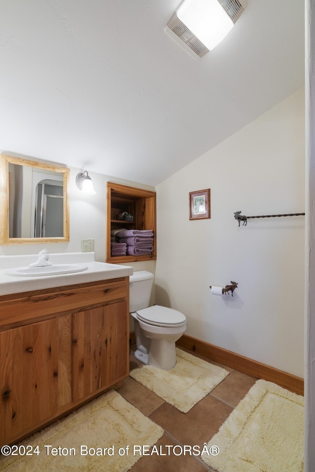 14 Table Top Dr, Dubois, WY 82513 - bathroom featuring vanity, vaulted ceiling, toilet, tile patterned floors, and baseboards
