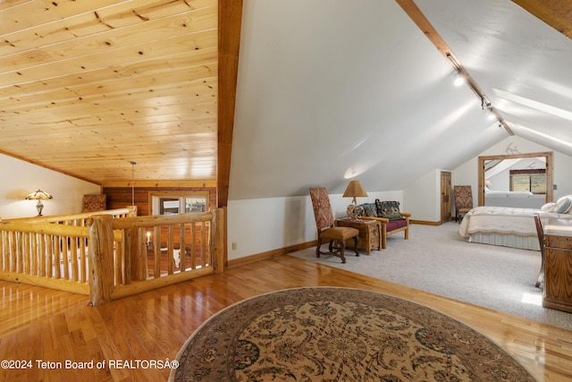14 Table Top Dr, Dubois, WY 82513 - bedroom featuring rail lighting, vaulted ceiling, baseboards, and wood finished floors