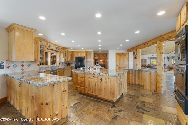14 Table Top Dr, Dubois, WY 82513 - kitchen featuring black fridge, a kitchen island with sink, recessed lighting, a warming drawer, and a peninsula