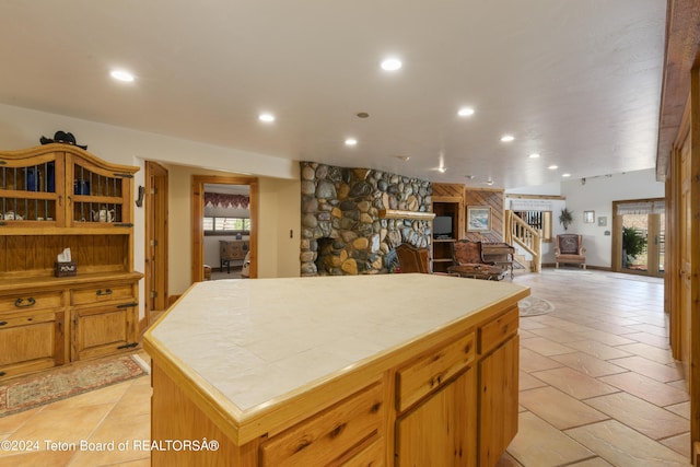 14 Table Top Dr, Dubois, WY 82513 - kitchen featuring tile counters, recessed lighting, a stone fireplace, a kitchen island, and open shelves