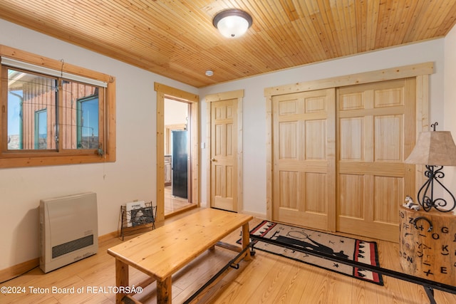 entrance foyer with heating unit, light wood-type flooring, and wood ceiling