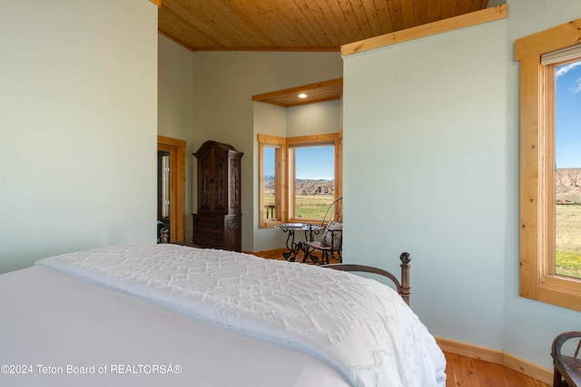 bedroom with multiple windows, wooden ceiling, lofted ceiling, and hardwood / wood-style floors