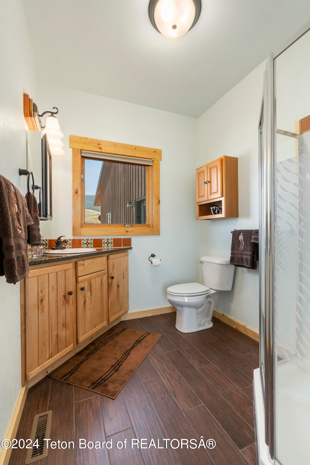 bathroom featuring wood-type flooring, toilet, and vanity