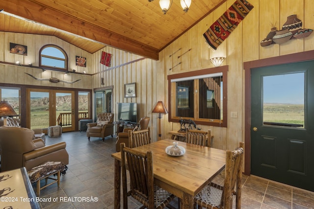28 Table Top Dr, Dubois, WY 82513 - dining area featuring high vaulted ceiling, wood ceiling, stone tile flooring, and wood walls