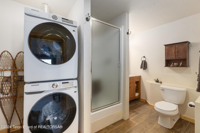 28 Table Top Dr, Dubois, WY 82513 - laundry area with stacked washing machine and dryer, wood finished floors, and baseboards