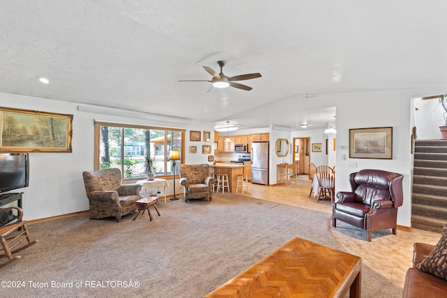 living room with ceiling fan, vaulted ceiling, and light colored carpet