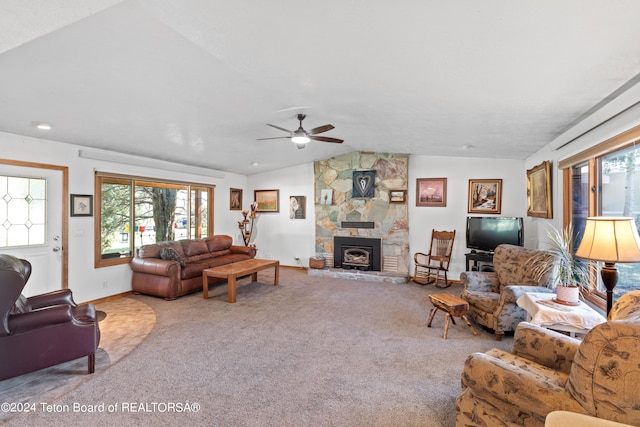 carpeted living room featuring a fireplace, ceiling fan, and vaulted ceiling