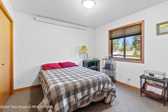 bedroom with a textured ceiling and baseboards