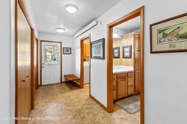 tiled foyer entrance with washer / clothes dryer and a textured ceiling