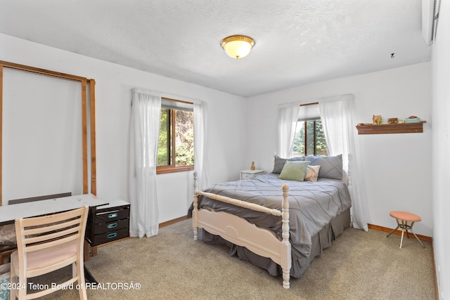 bedroom with a textured ceiling and light colored carpet