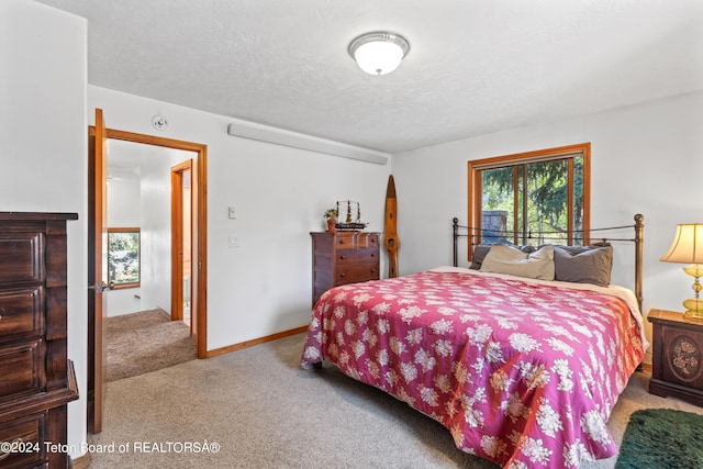 bedroom featuring light colored carpet and a textured ceiling