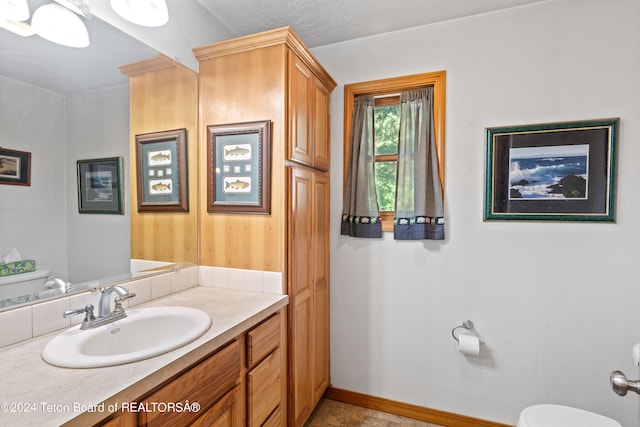 bathroom with vanity, toilet, tile patterned floors, and a textured ceiling