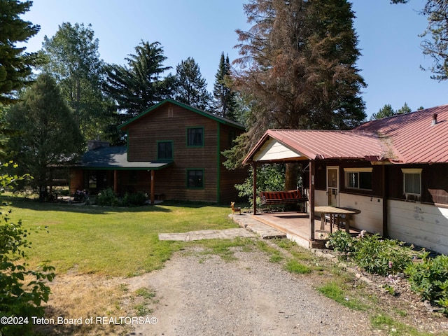 back of house featuring a lawn and metal roof