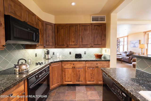 kitchen featuring decorative backsplash, dark stone counters, and black appliances