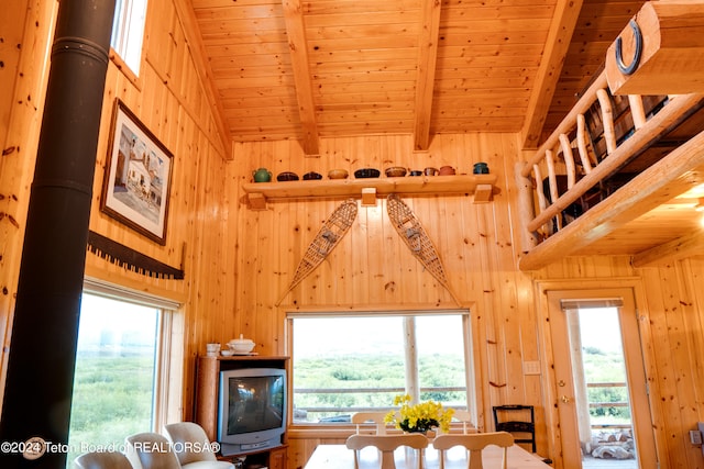 living room with wood walls, wooden ceiling, and beamed ceiling