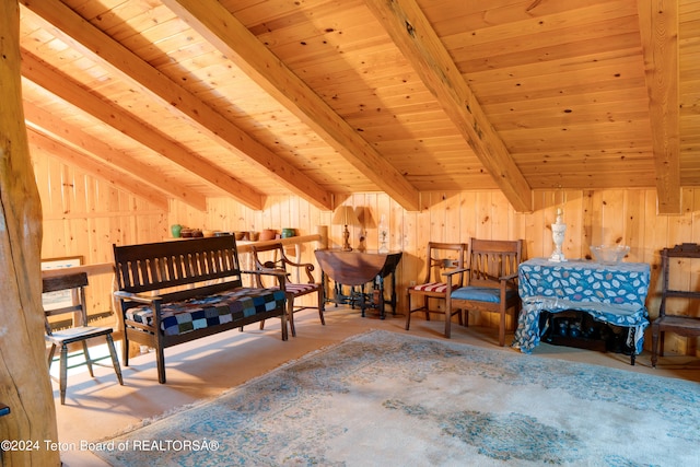 sitting room featuring wood walls, vaulted ceiling with beams, and wooden ceiling