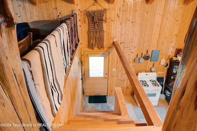 stairway featuring wood walls