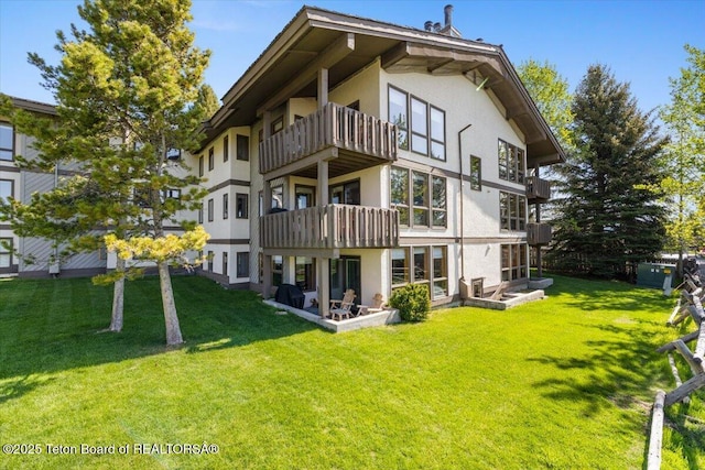 3600 W Michael Dr Unit D-4-2, Teton Village, WY 83014 - back of property featuring stucco siding, a balcony, and a lawn